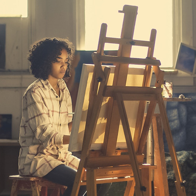 Woman in front of easel.